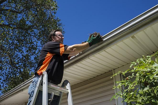 a gutter repair specialist working on a home in Andover